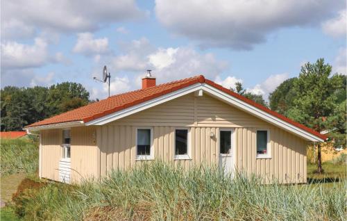 a small house with a red roof in a field at Schmugglerstieg 2 - Dorf 6 in Priwall