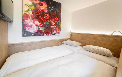 a bed in a room with a painting on the wall at Awesome Apartment In Wagrain With 2 Bedrooms, Wifi And Outdoor Swimming Pool in Wagrain