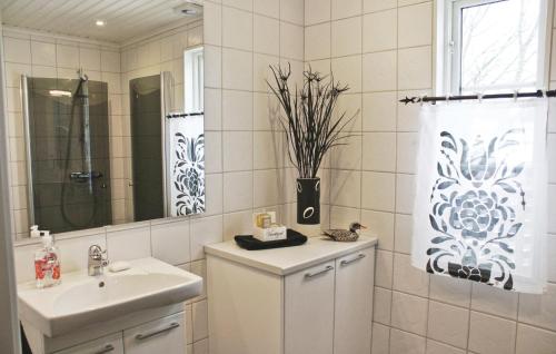 uma casa de banho branca com um lavatório e um espelho em Nice Home In Vetlanda With Wifi em Skirö
