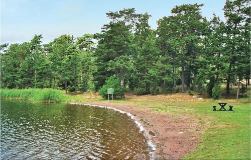 a bench next to a body of water with trees at Oknö in Mönsterås