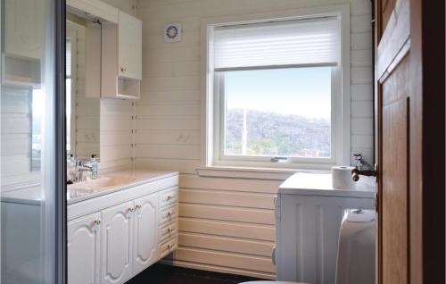 ein Bad mit einem Waschbecken und einem Fenster in der Unterkunft Awesome Home In Hauglandshella With Kitchen in Kolavåg