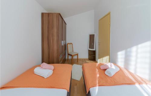 2 letti in camera d'albergo con asciugamani rosa e bianchi di Pet Friendly Apartment In Labin With Kitchen a Labin