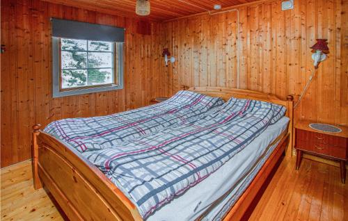 Cama en habitación de madera con ventana en Amazing Home In Farstad With House Sea View, en Farstad