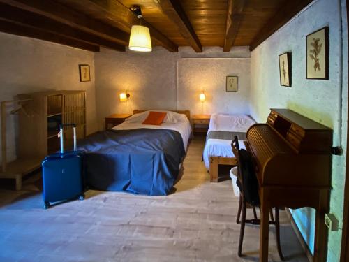 a bedroom with two beds and a piano at El Buxaus de la Muntanya in Arbúcies