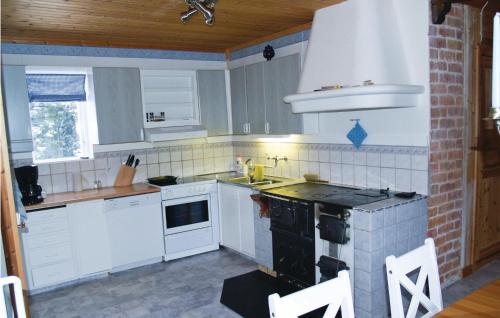 a kitchen with white cabinets and a stove top oven at Beautiful Home In Lesjöfors With Sauna in Kosundet