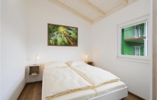 a white bedroom with a bed and a window at Ferienhausdorf Thale in Thale