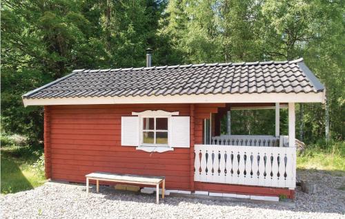 a small red shed with a bench in front of it at Beautiful Home In Lesjöfors With Sauna in Kosundet