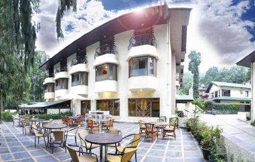 a hotel with tables and chairs in front of a building at Vikram Vintage Inn in Nainital