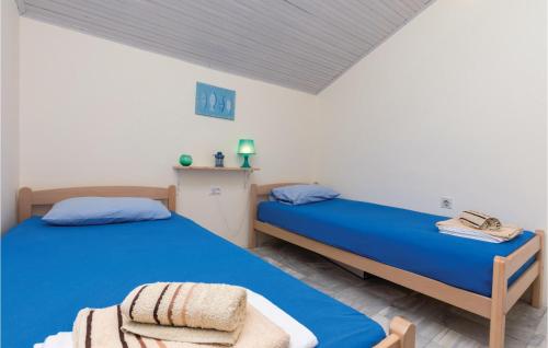 two beds in a room with blue sheets at Beautiful Apartment In Utjeha in Utjeha