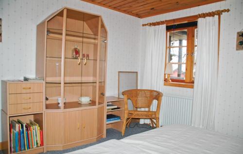 1 dormitorio con armario de madera, escritorio y silla en Nice Home In Uddevalla With 3 Bedrooms And Wifi, en Häljebol