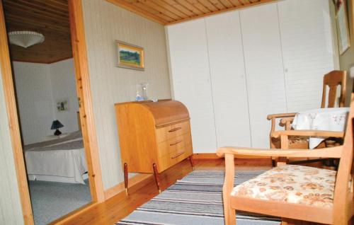 a room with a bedroom with a table and a chair at Cozy Home In Uddevalla With Wifi in Häljebol