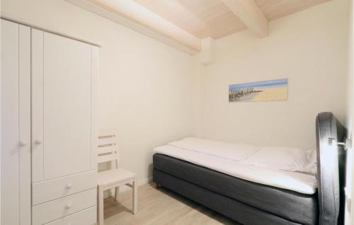 ein kleines Schlafzimmer mit einem Bett und einem Schrank in der Unterkunft Ferienhaus Dageb�ll K�stenweg VI in Dagebüll