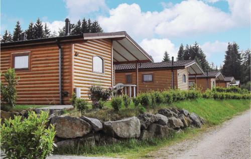 a log cabin on a hill next to a gravel road at 2 Bedroom Cozy Home In Gerolstein in Gerolstein