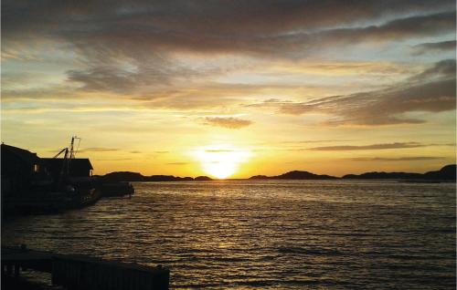 a sunset over a body of water with the sun setting at Beautiful Apartment In Skärhamn in Skärhamn