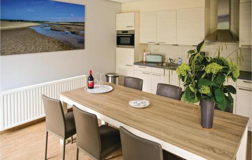 a dining room table with chairs and a vase with a plant at Nice Home In Retranchement With Wifi in Retranchement