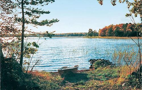 a bench sitting on the shore of a lake at Gorgeous Home In Ruda With Kitchen in Ruda