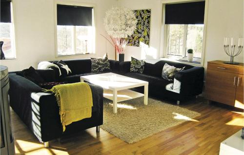 a living room with a black couch and a table at Cozy Home In Jönköping With Wifi in Norrahammar