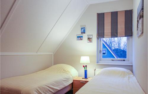 Duas camas num quarto com uma janela em Awesome Home In Zonnemaire With 3 Bedrooms And Wifi em Zonnemaire