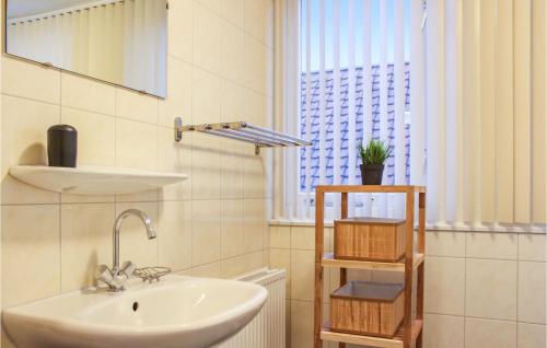 uma casa de banho com um lavatório, um espelho e uma janela em Awesome Home In Zonnemaire With 3 Bedrooms And Wifi em Zonnemaire