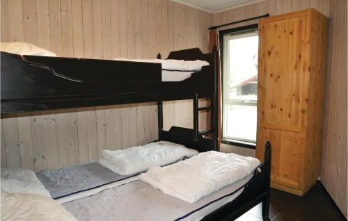 two bunk beds in a room with a window at Beautiful Apartment In Hemsedal With 3 Bedrooms, Sauna And Wifi in Hemsedal