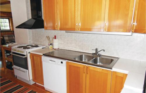 a kitchen with a sink and a stove at Nice Home In Kälarne With Sauna in Övsjöbyn
