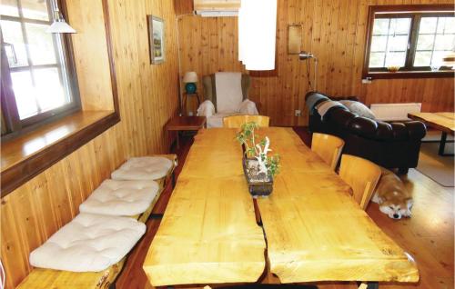 a dining room with a long wooden table and a dog at Nice Home In Kälarne With Sauna in Övsjöbyn