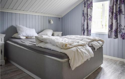 a bed in a bedroom with blue walls at Amazing Home In Ballangen With 2 Bedrooms And Wifi in Ballangen