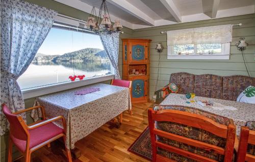 a dining room with a table and a window at Holiday Home Vågstranda Hjelvik Ii in Reistad