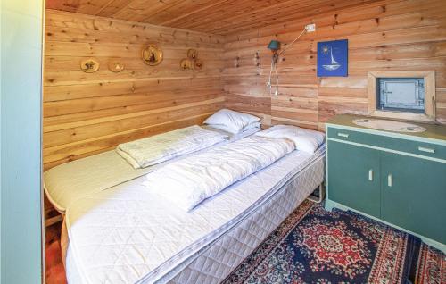 duże łóżko w drewnianym pokoju z umywalką w obiekcie Awesome Home In Vgstranda With House Sea View w mieście Reistad