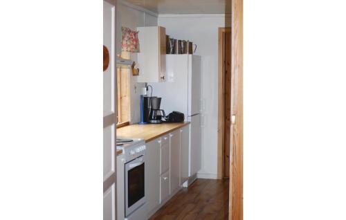 a kitchen with white cabinets and a stove top oven at Beautiful Home In Tysse With Kitchen in Kleivi