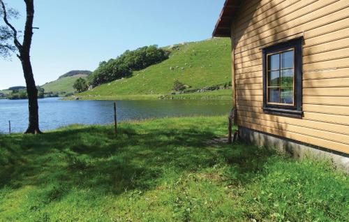 a building with a window next to a body of water at Cozy Apartment In Sandnes With Kitchen in Bråstein