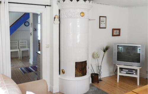 a white fireplace in a living room with a tv at One-Bedroom Holiday Home In Jonkoping in Jönköping