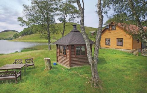 a cabin with a table and a bench next to a lake at Cozy Apartment In Sandnes With Kitchen in Bråstein