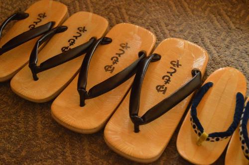 four pairs of sandals are lined up on the floor at Yumotoya in Matsumoto