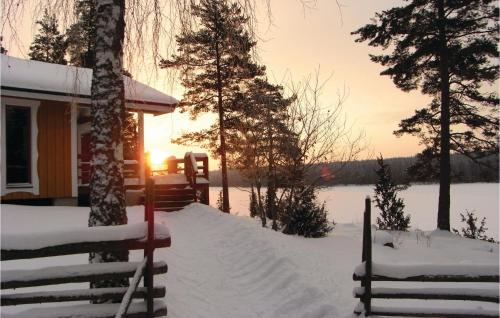 a cabin in the snow with the sun setting in the background at Pet Friendly Home In Fröseke With Sauna in Fröseke