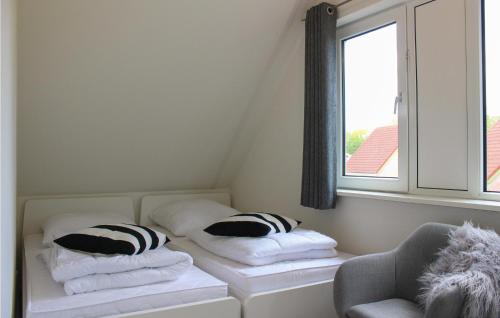 een kamer met een bed met kussens en een raam bij Awesome Home In Vlagtwedde With 3 Bedrooms, Wifi And Indoor Swimming Pool in Vlagtwedde