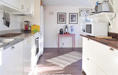 a kitchen with white cabinets and a wooden floor at Holiday Home Lärbro 46 in Valleviken