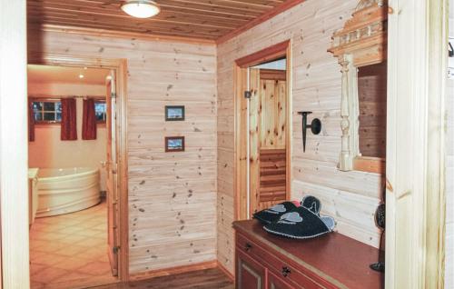 Habitación con paredes de madera y habitación con bañera. en Eikhaugen Gjestegard en Vinnes