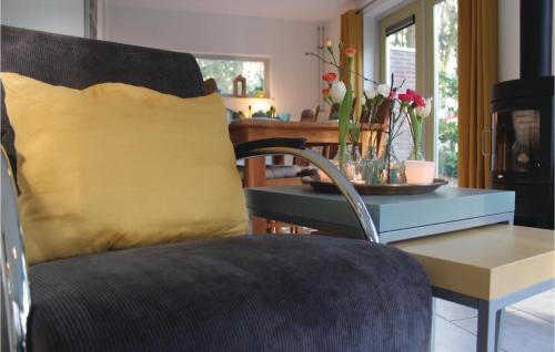 a living room with a chair and a table with a yellow pillow at Fonteinbos in Oudemirdum