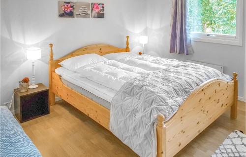 a bedroom with a large bed with a wooden frame at Gorgeous Home In Vikanes With Kitchen in Eikemo