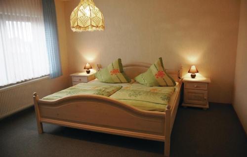 a bedroom with a bed with two night stands and a chandelier at Nice Apartment In Brilon-madfeld With 3 Bedrooms And Wifi in Madfeld