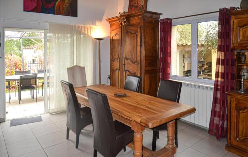 une salle à manger avec une table et des chaises en bois dans l'établissement 3 Bedroom Amazing Home In Villetelle, à Villetelle