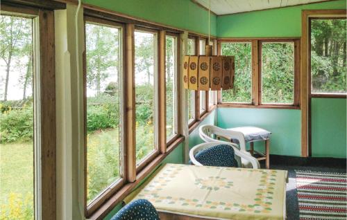 VikにあるAmazing Home In Arvika With Lake Viewのテーブルと椅子、窓が備わる客室です。
