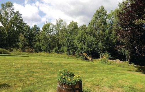a field with a wooden barrel with flowers in it at Holiday Home Asarum Gamla Tingsrydsvägen in Askaremåla