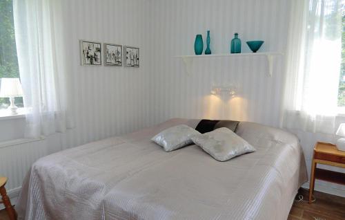 a bedroom with a bed with two pillows on it at Holiday Home Asarum Gamla Tingsrydsvägen in Askaremåla