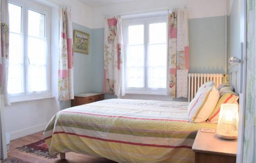 ein Schlafzimmer mit einem Bett und zwei Fenstern in der Unterkunft Cozy Home In Gavray With Kitchen in Gavray