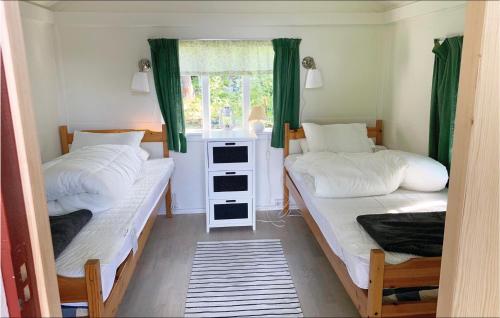 two beds in a small room with a window at Amazing Home In Kvicksund With Wifi in Kvicksund