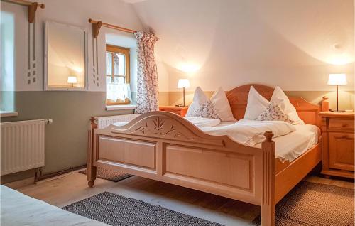 a bedroom with a wooden bed with white sheets and pillows at Awesome Home In Mrzsteg With Jacuzzi, Sauna And Wifi in Mürzsteg