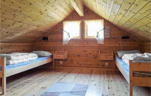 two beds in a log cabin with a window at Cozy Home In Varaldsy With Kitchen in Gjuvsland