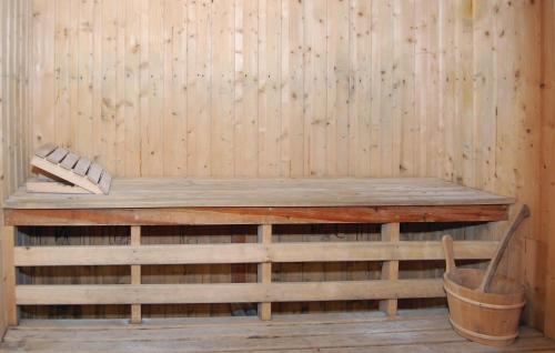 a wooden sauna with a bench and a bucket at Nice Home In Olofström With Sauna in Olofström